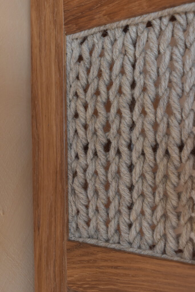 tricot de laine et bois de chêne sur une étagère bibliothèque