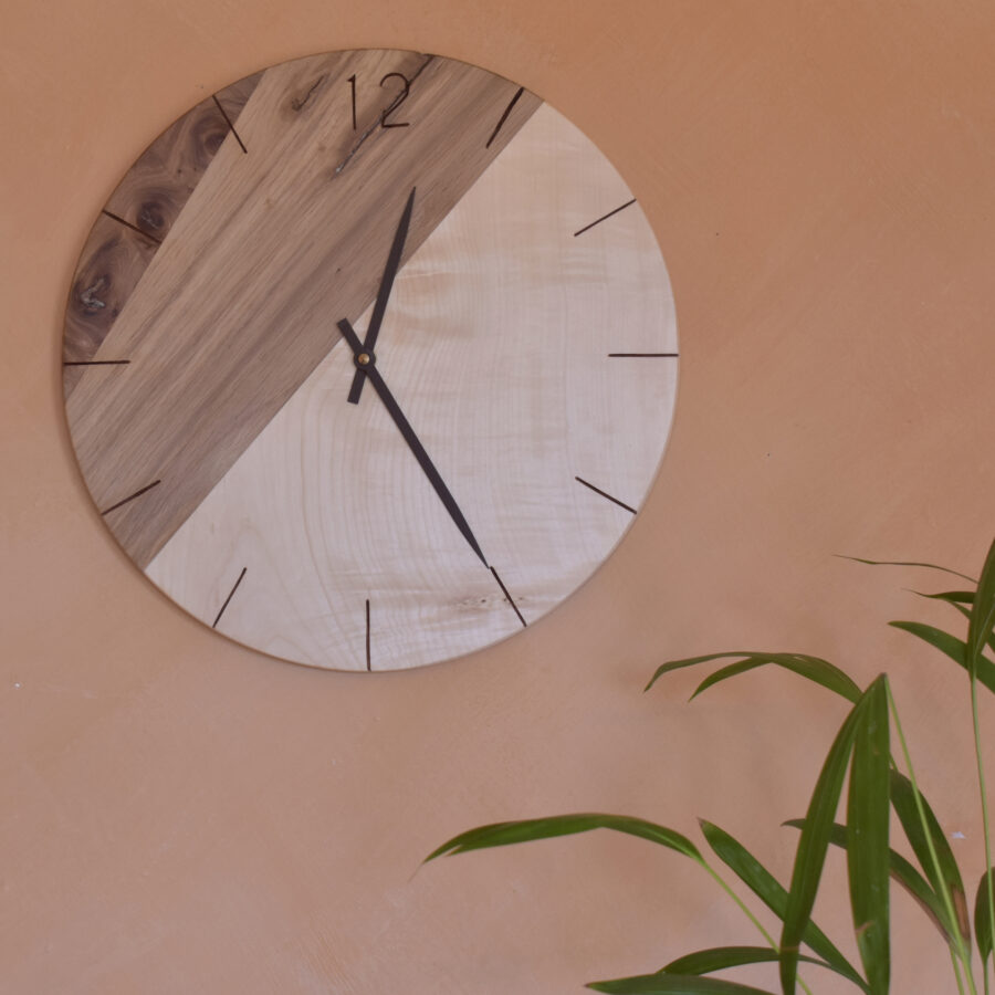 horloge murale ronde en bois et plante verte sur mur rose