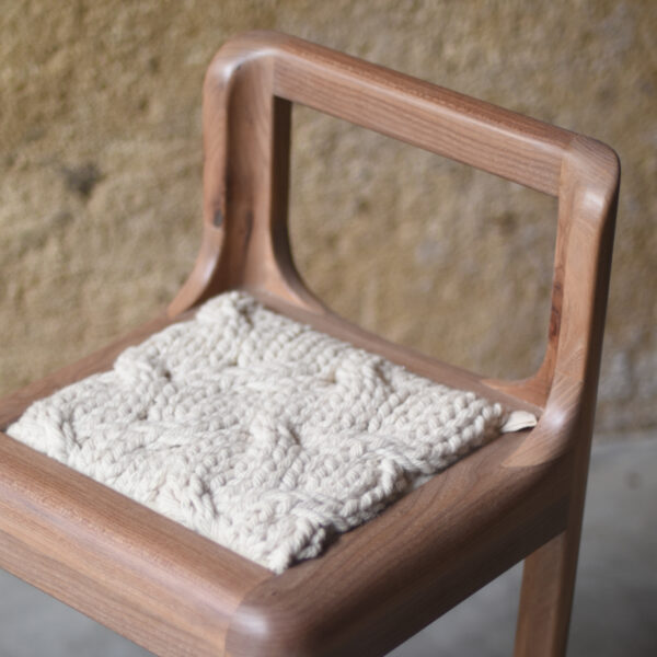 détail d'une chaise en bois et laine artisanale